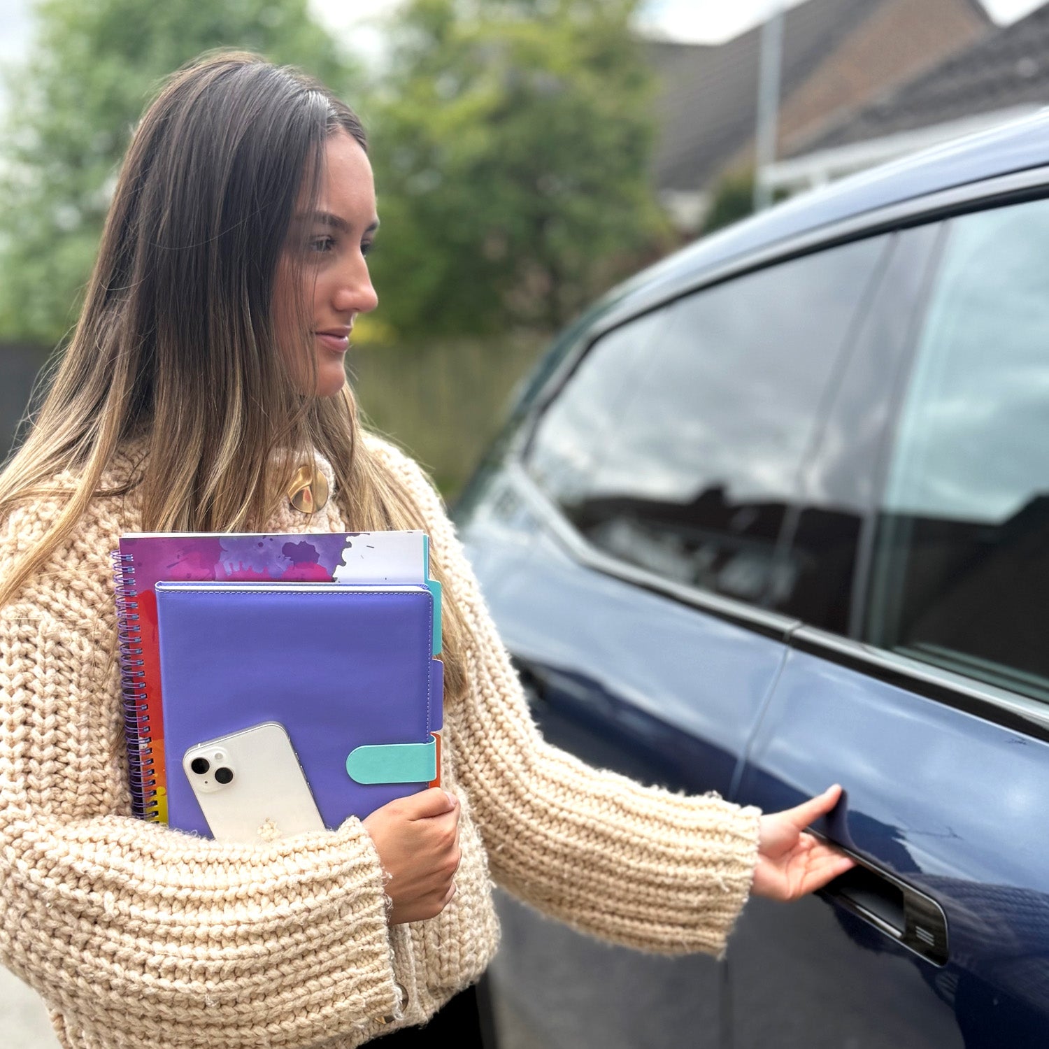 girls getting in car at uni with bright notebooks for note taking at university