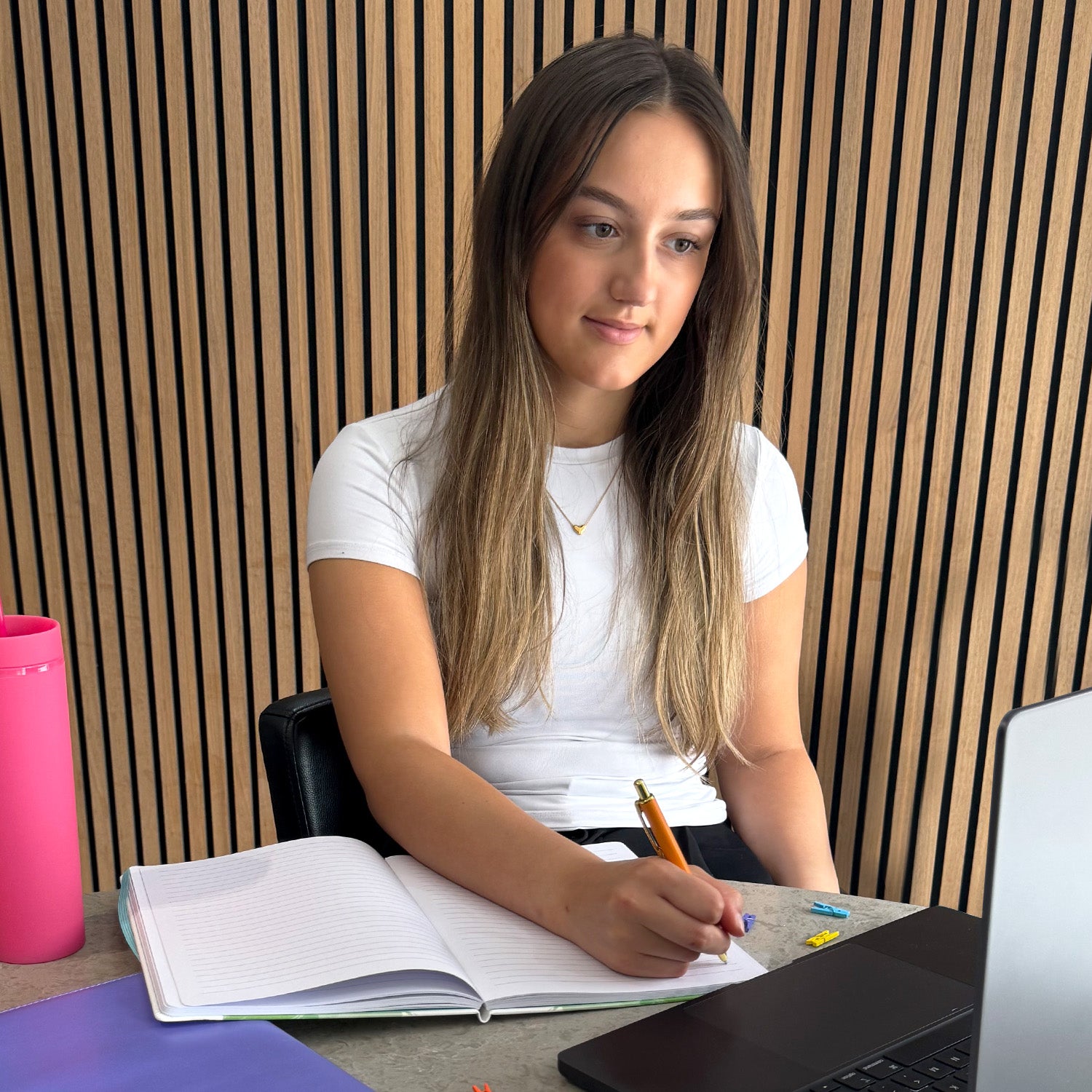 girl student writing with ballpoint pen at college with her stationery set